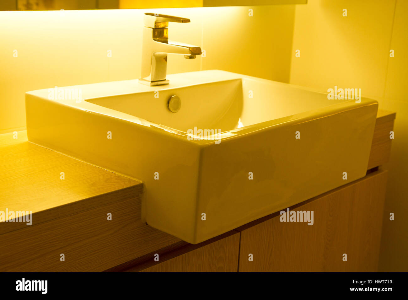 Closeup of a modern stainless steel faucet on white porcelain sink