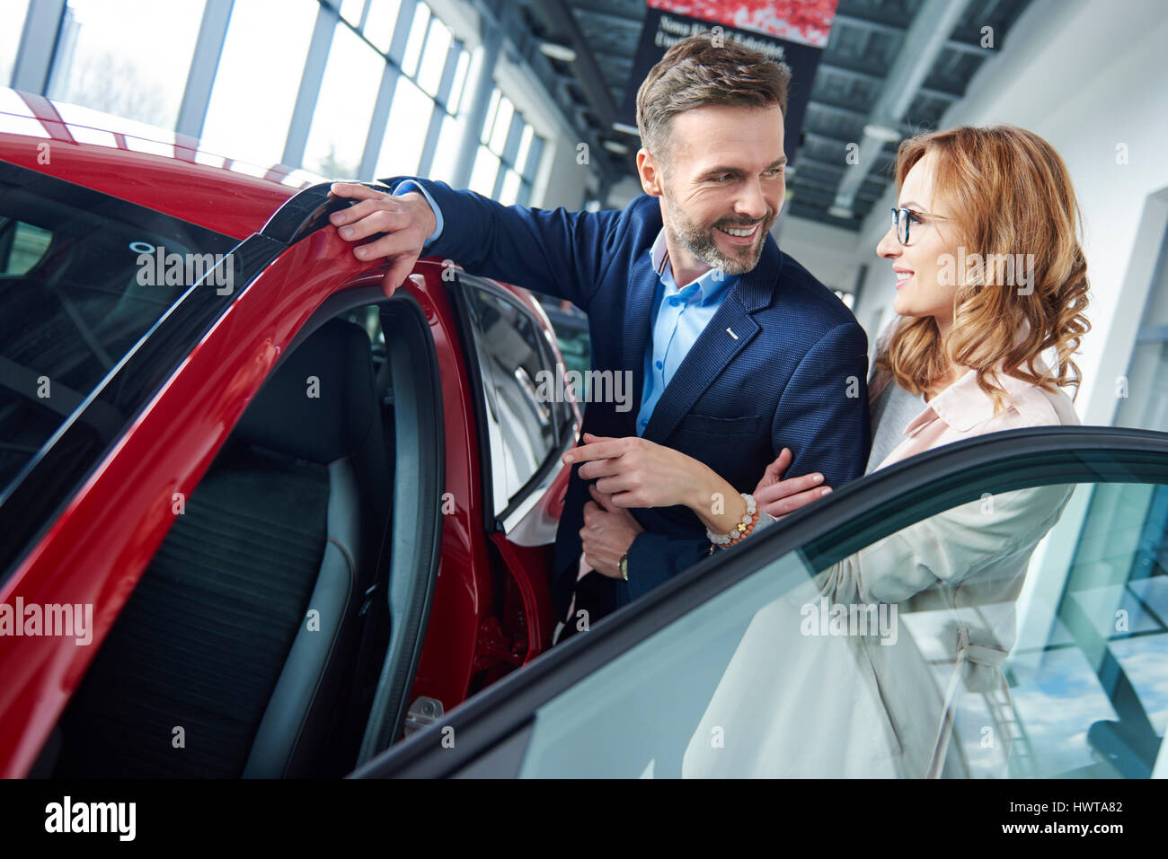 Couple testing new cars in the showroom Stock Photo