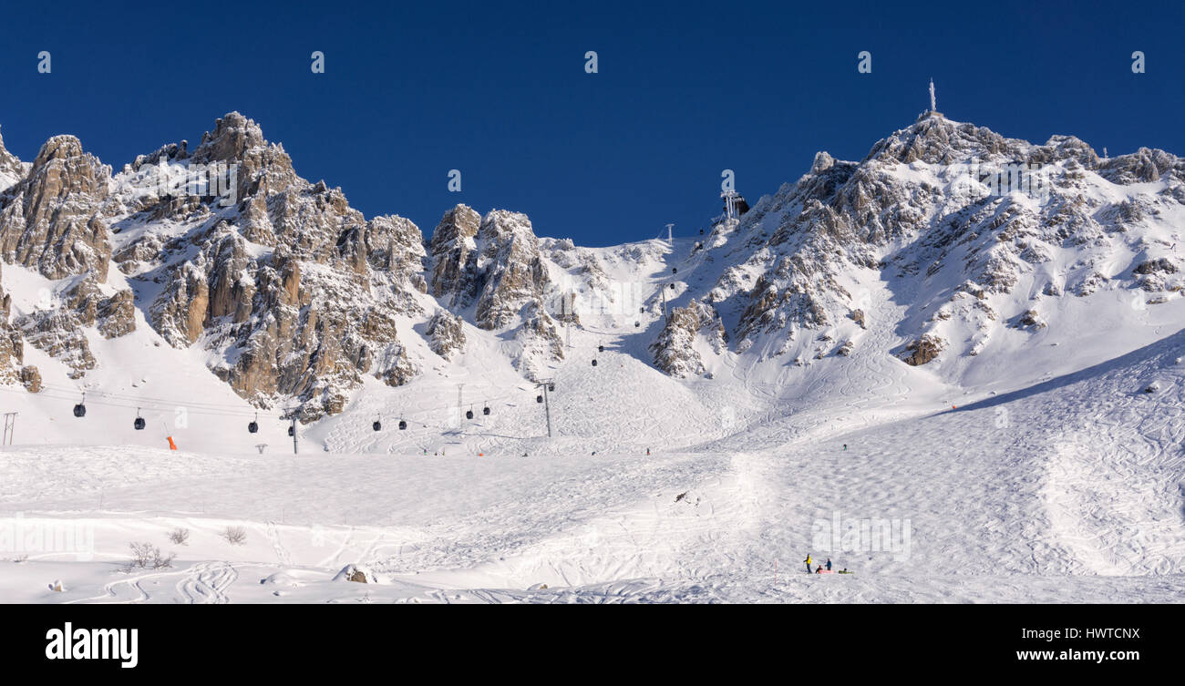 Ski lifts, skiers, snow boarders and pistes above the French ski resort of Les Menuires in the Three Valleys in France Stock Photo