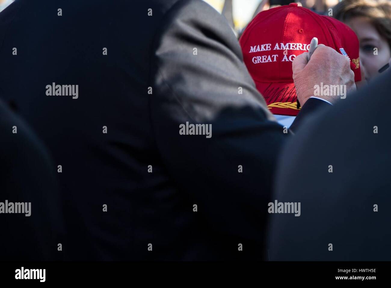 U.S President Donald Trump signs a hat for a greeter after arriving at the Palm Beach International Airport February 3, 2017 in Palm Beach, Florida. Stock Photo