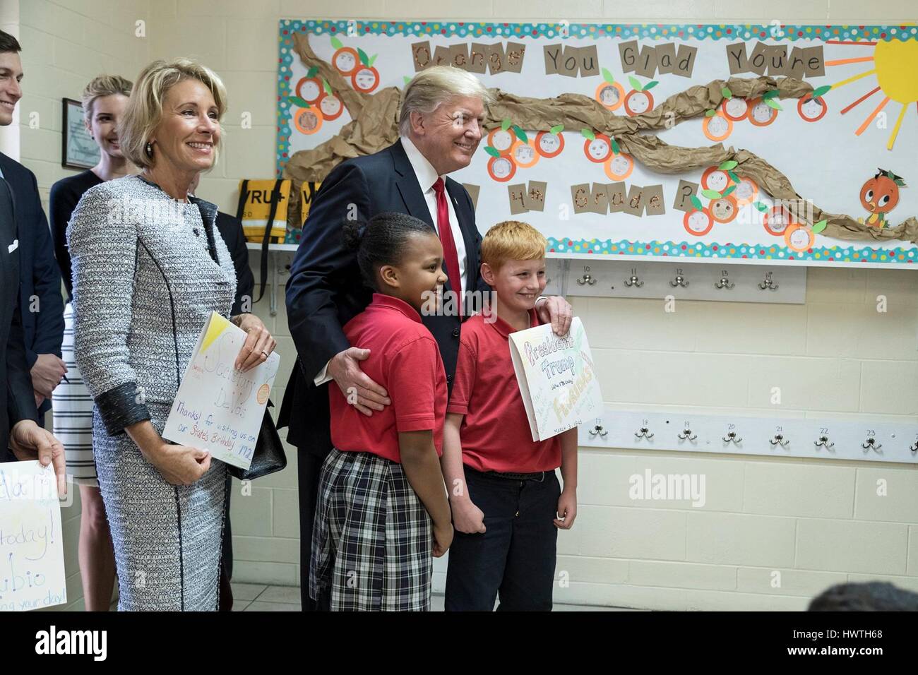 U.S President Donald Trump and Secretary of Education Betsy DeVos, left, pose for a photo with students of Saint Andrew Catholic School during a tour of the school March 3, 2017 in Orlando, Florida. Stock Photo