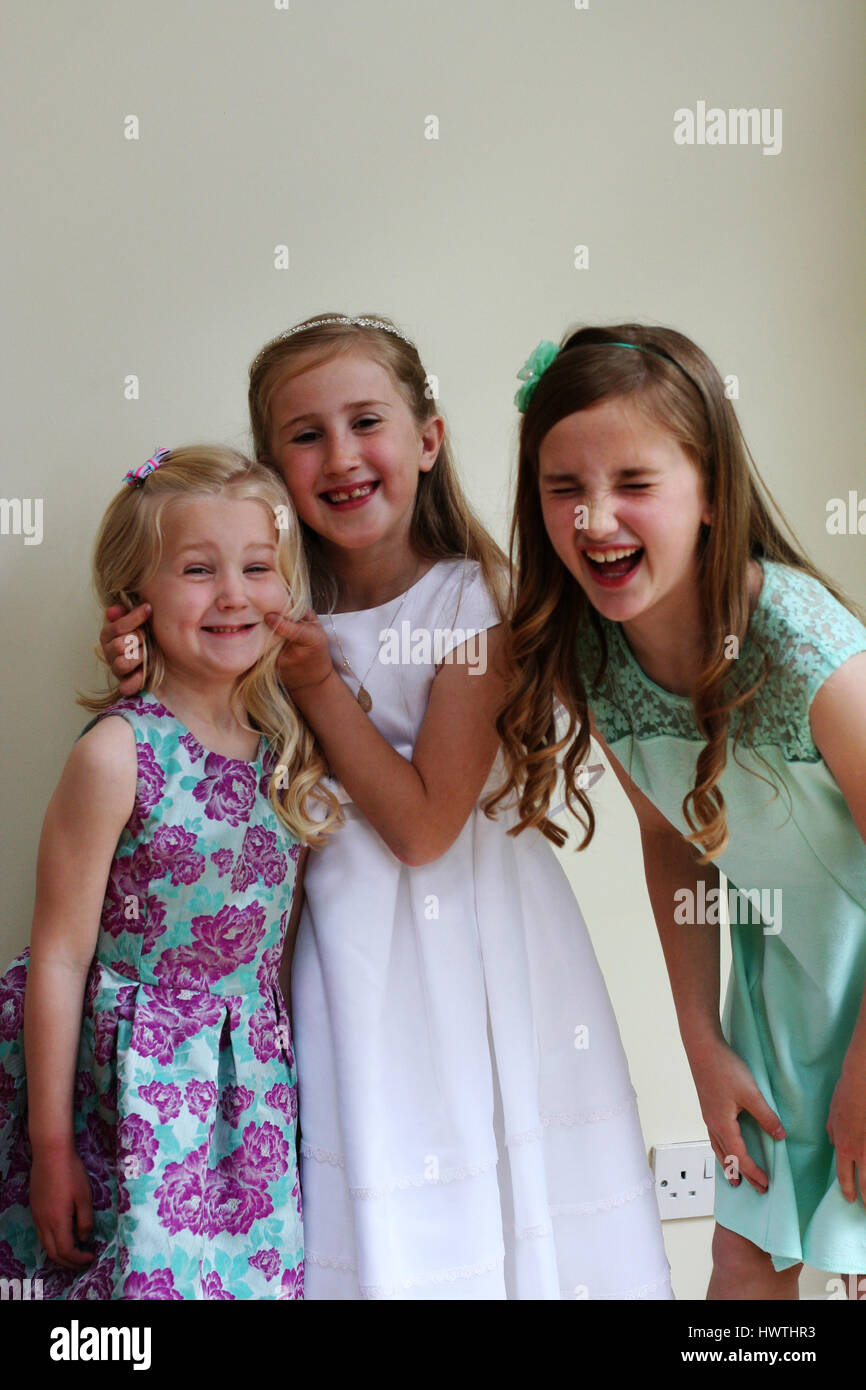 Three girls having fun together on a First Holy Communion Day joy concept, happiness, laughing out loud, childhood, happy family fun ecstatic happy Stock Photo