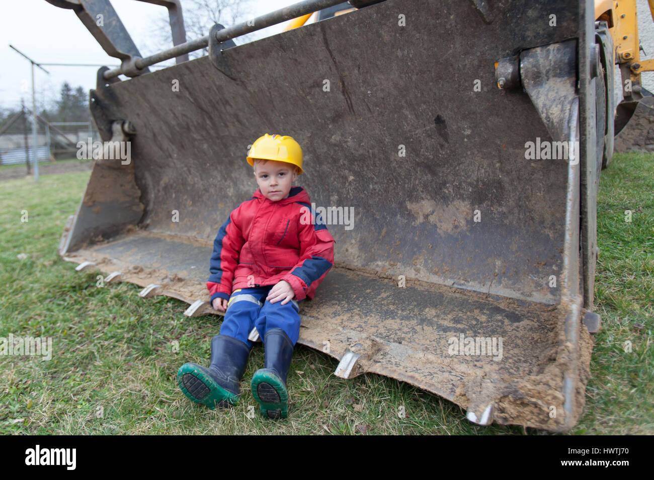 Little boy with a spade helps parents during the construction of the ...