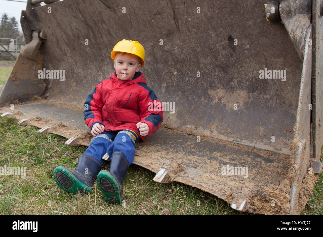 Little boy with a spade helps parents during the construction of the ...