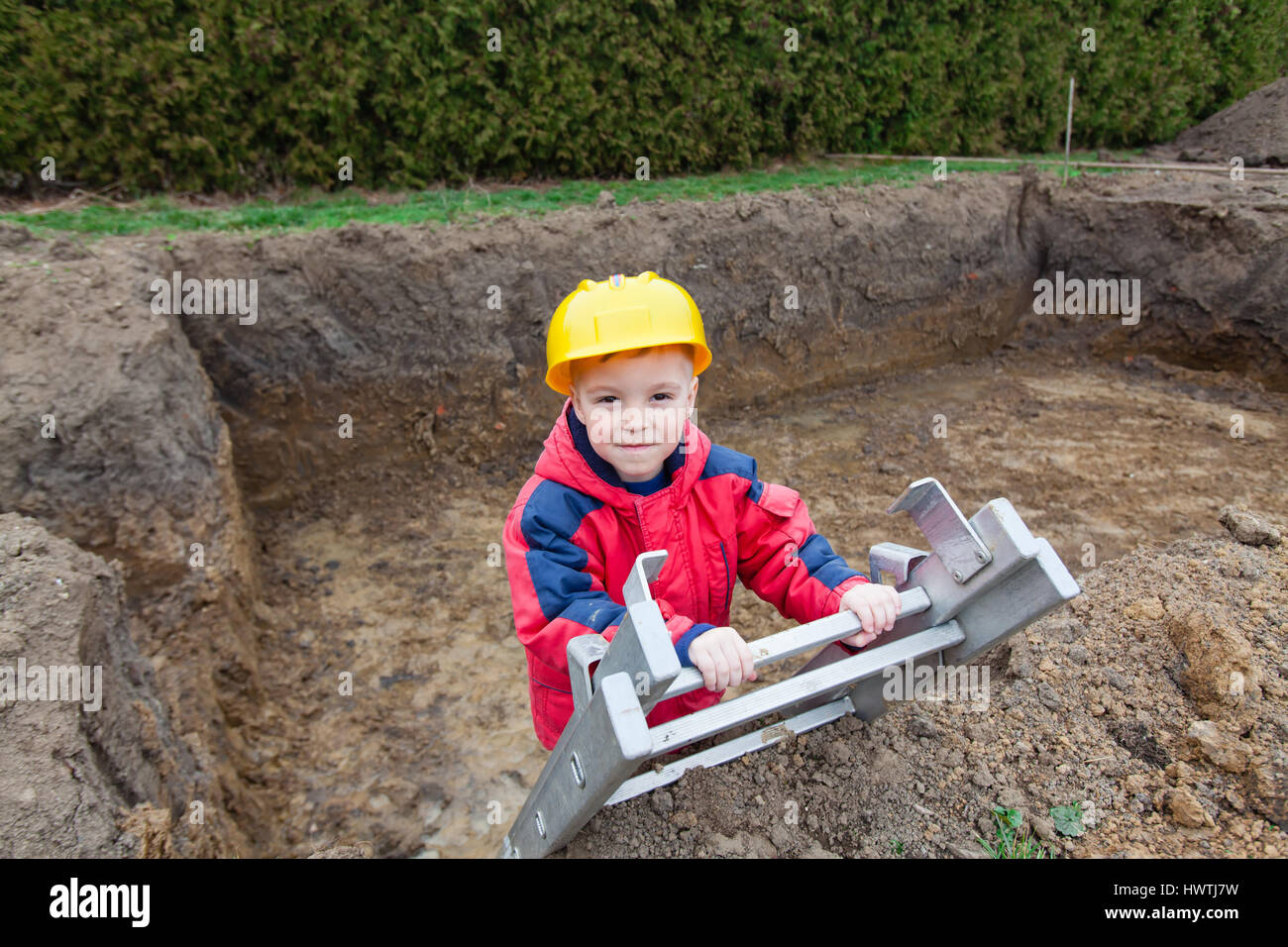 Little boy with a spade helps parents during the construction of the ...