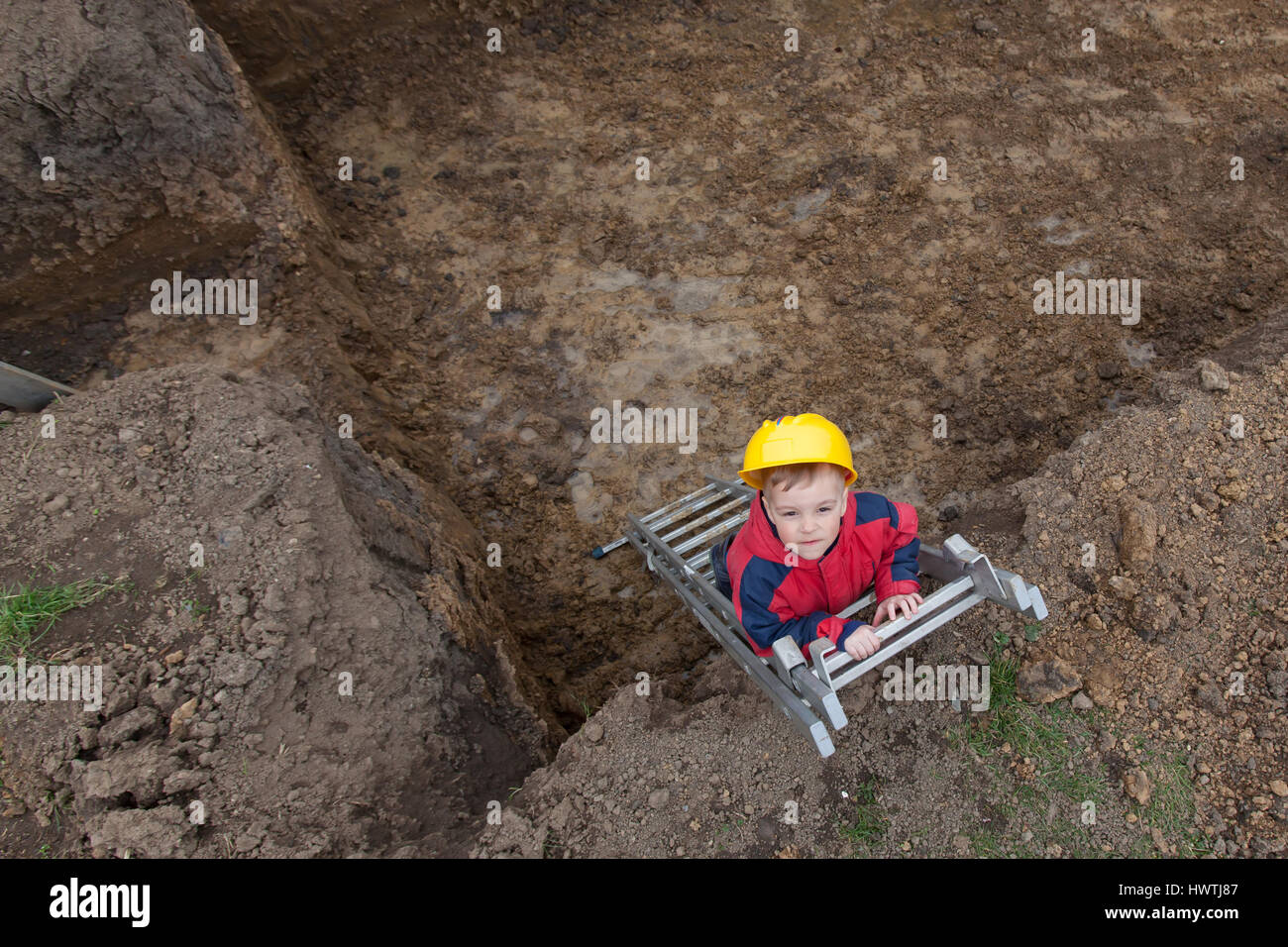 Little boy with a spade helps parents during the construction of the ...