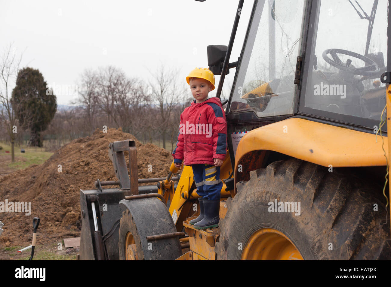 Little boy with a spade helps parents during the construction of the ...