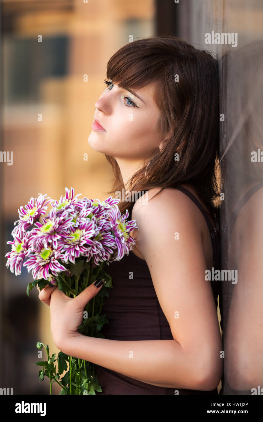 Sad young woman with a flowers Stock Photo - Alamy