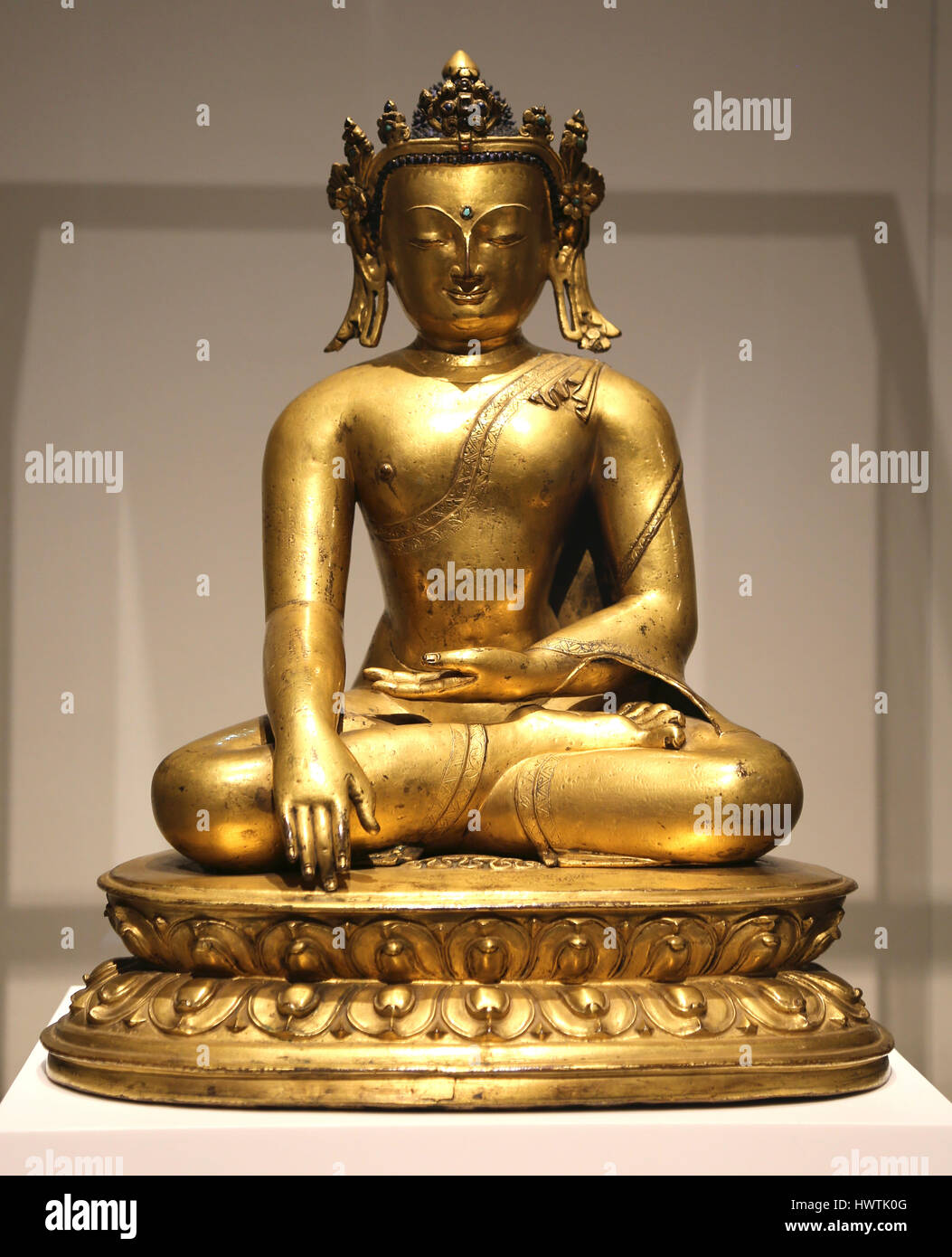 Crowned historical Buddha Sakyamuni. Tibet-Nepal, 15th C. 16th C. Golden copper scuplture. Stock Photo