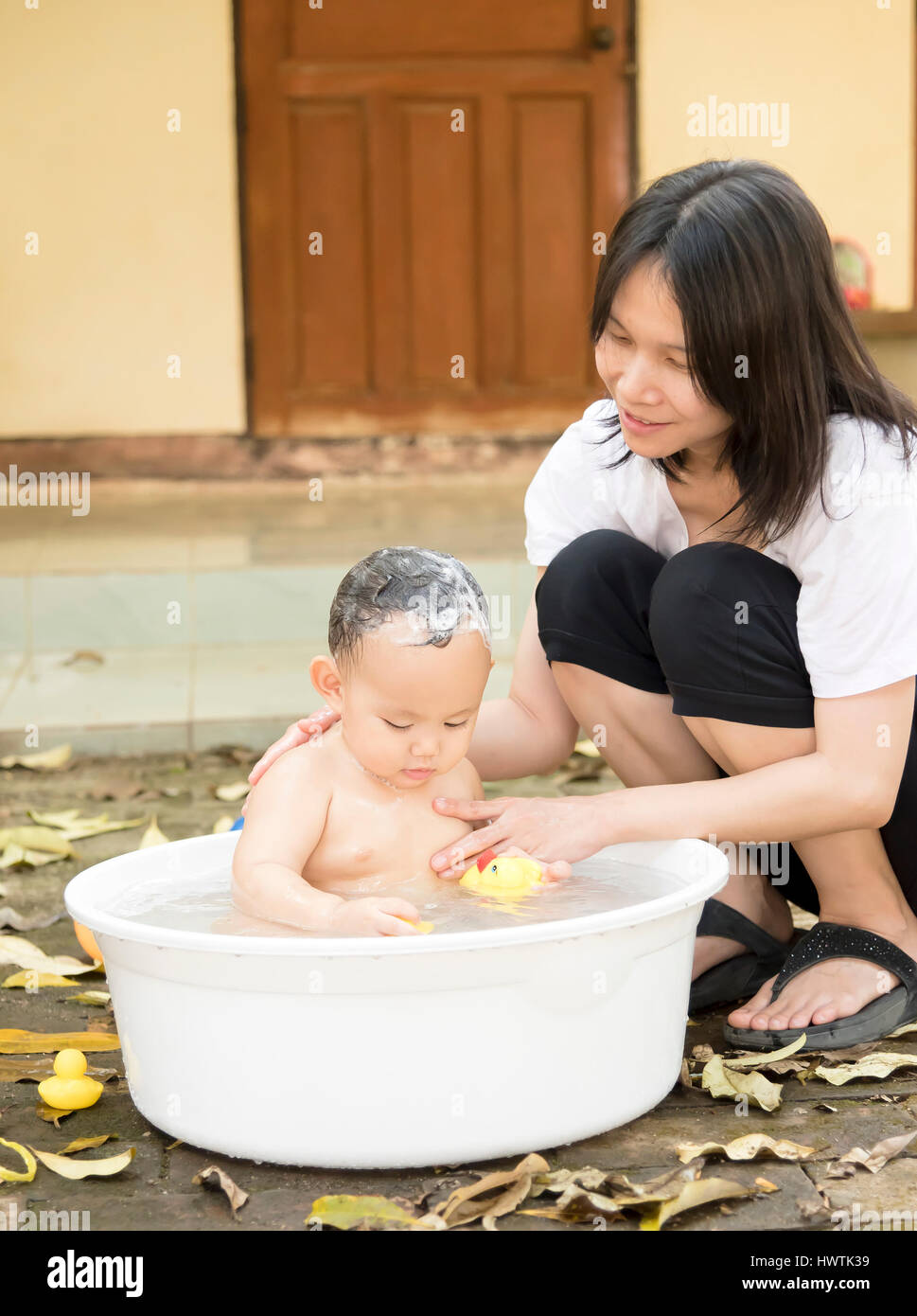 Asian baby boy was bathing and shampooing by mother in the white bathtub .  He is playing yellow duck full of happiness, Country side culture of Thai  Stock Photo - Alamy