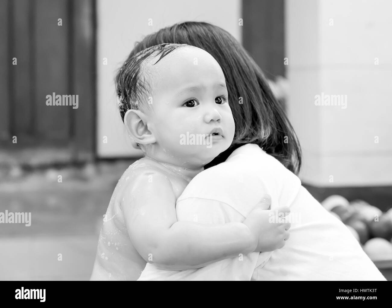 Fear , Asian baby in motion of fearing . His hand holding mother tightly in the mother hug. Stock Photo