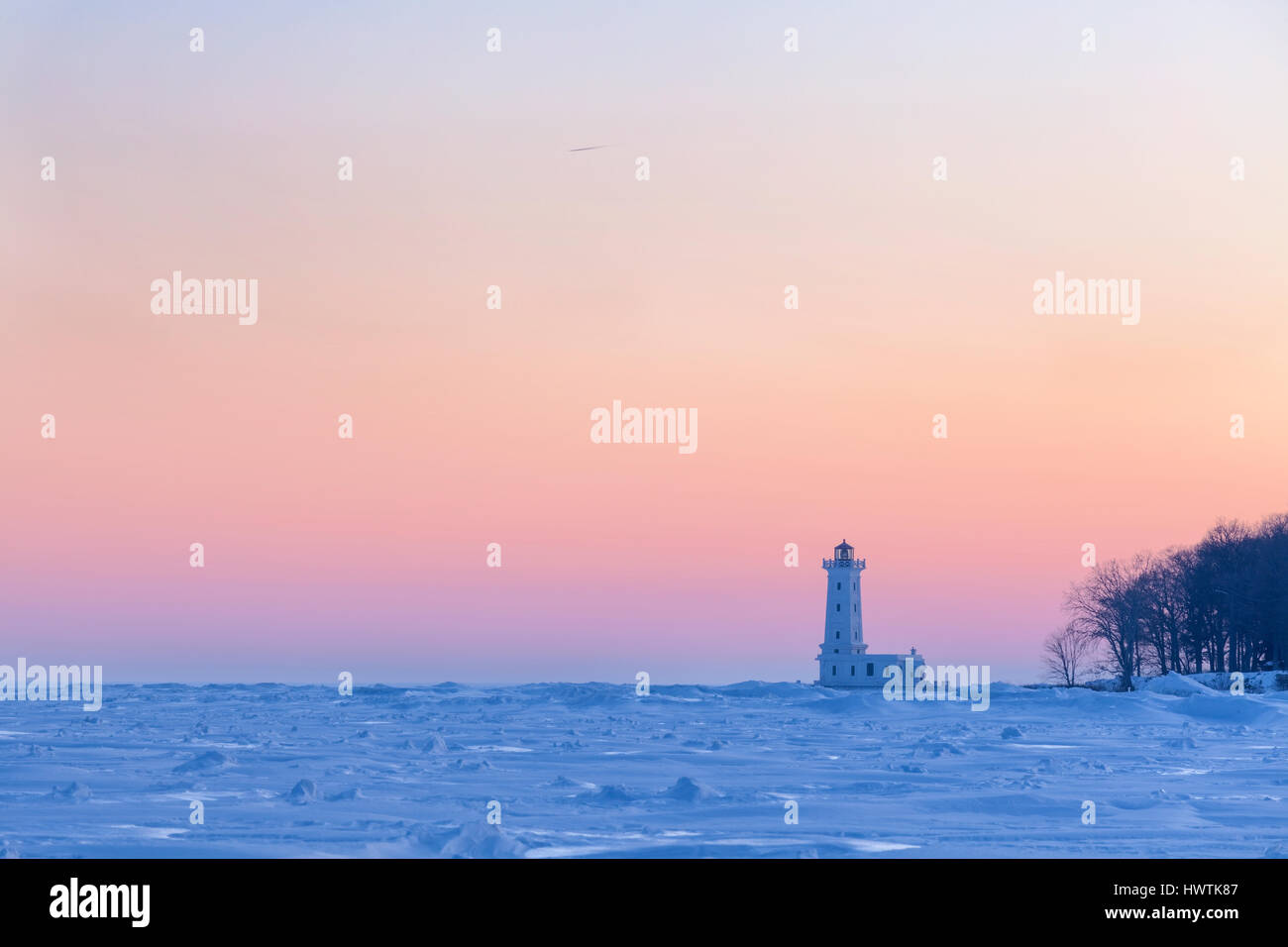 The Point Abino Light Tower at sunset on the frozen Lake Erie shores in Ridgeway, Ontario, Canada. Stock Photo