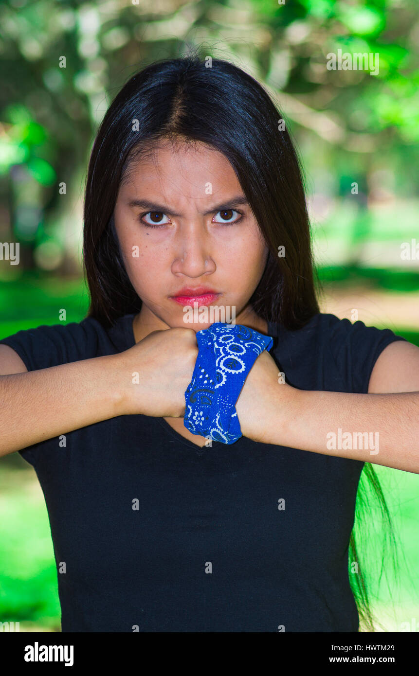 Young brunette woman wearing blue bandana around wrist, interacting angryv  for camera outdoors, activist protest concept Stock Photo - Alamy