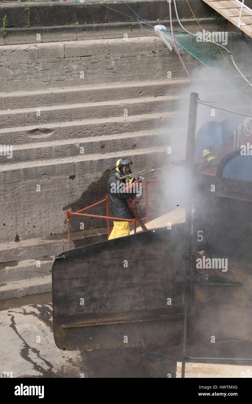 Cleaning the hull of unpowered barge Sabrina 5 in Gloucester drydock