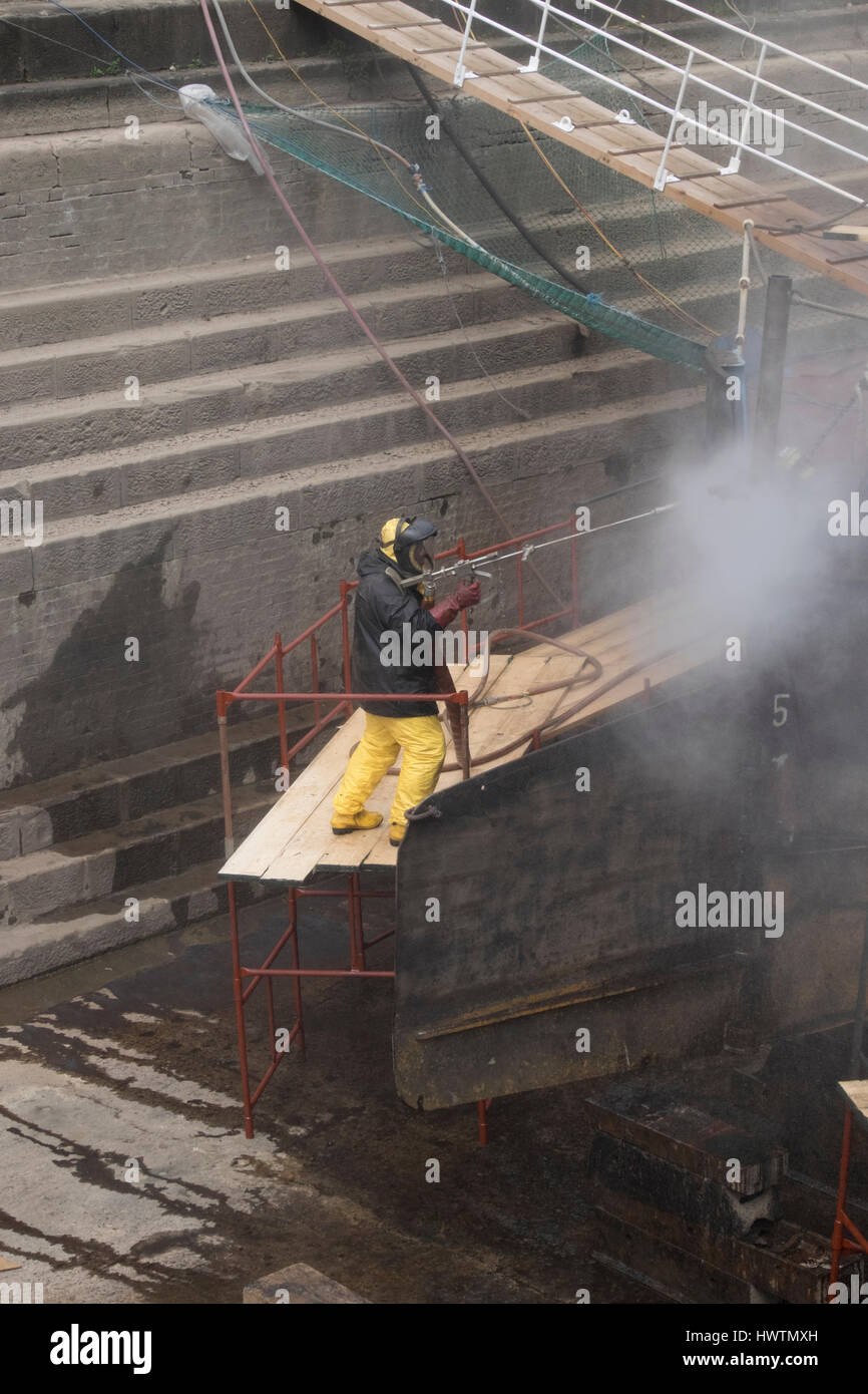 Cleaning the hull of unpowered barge Sabrina 5 in Gloucester drydock during repairs and