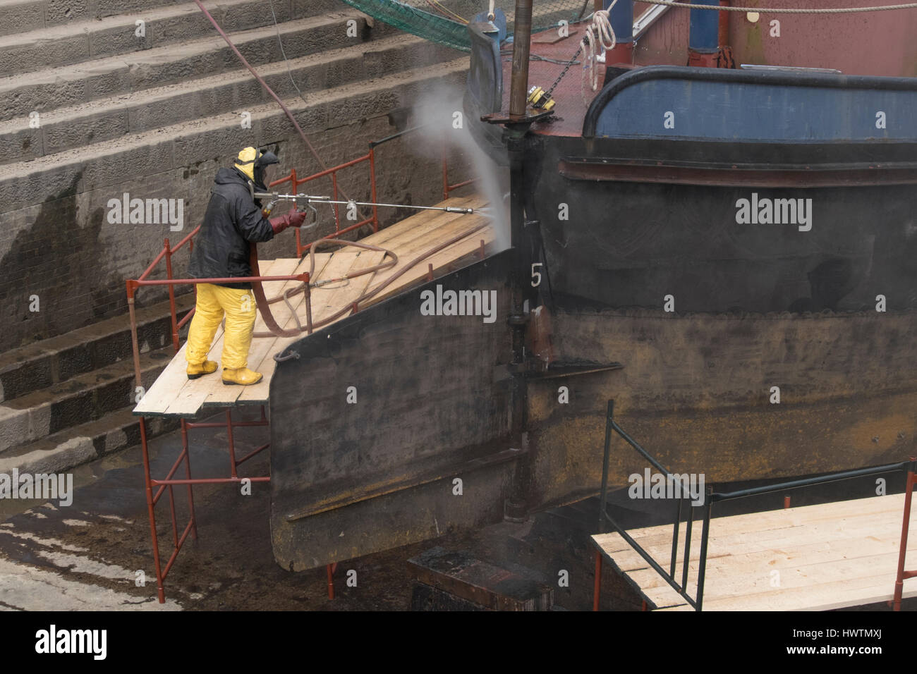Cleaning the hull of unpowered barge Sabrina 5 in Gloucester drydock