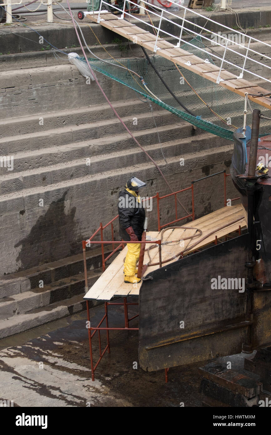 Cleaning the hull of unpowered barge Sabrina 5 in Gloucester drydock