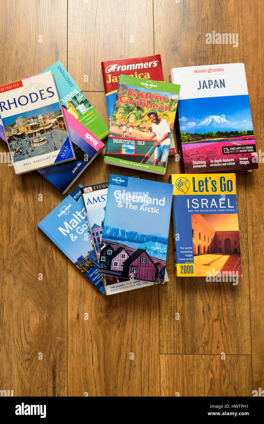 Trave guides laid on the floor from  above planning holiday destinations. Stock Photo
