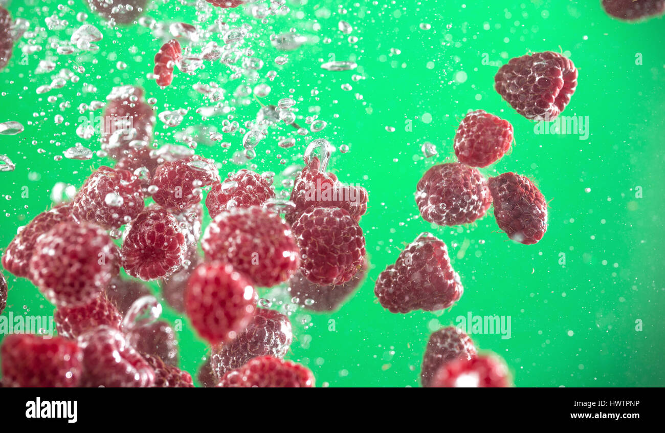 raspberry splashing in tank of water background Stock Photo - Alamy