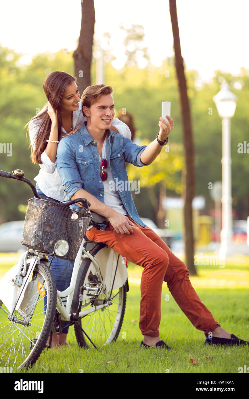 Couple with bicycles taking photo with smart phone Stock Photo