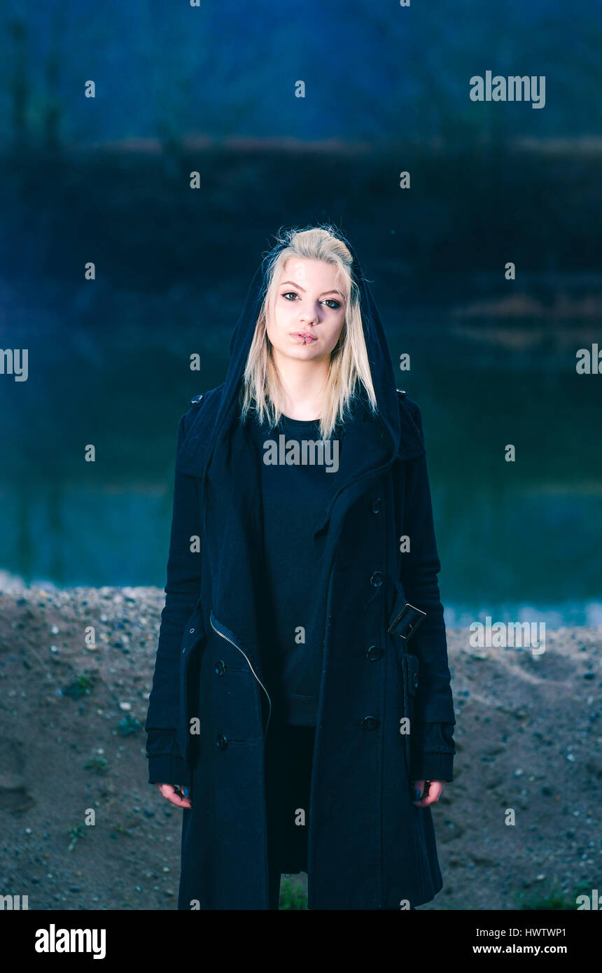Young female wearing black hood in nature night shot Stock Photo