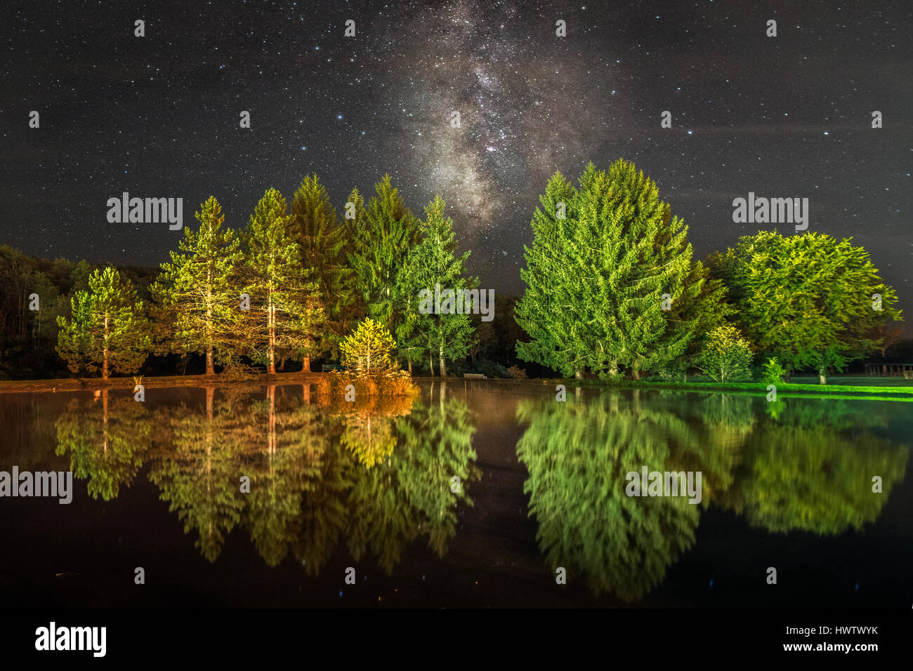 the Milky Way can be seen from within the city limits of Davis, West Virginia, as it is here reflecting in this pond in the park. Stock Photo