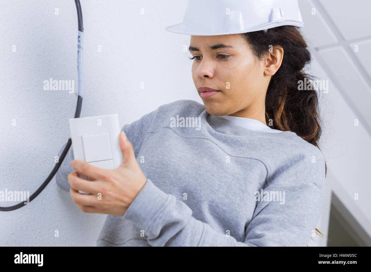 electrician woman installing light-switch in a new house Stock Photo ...