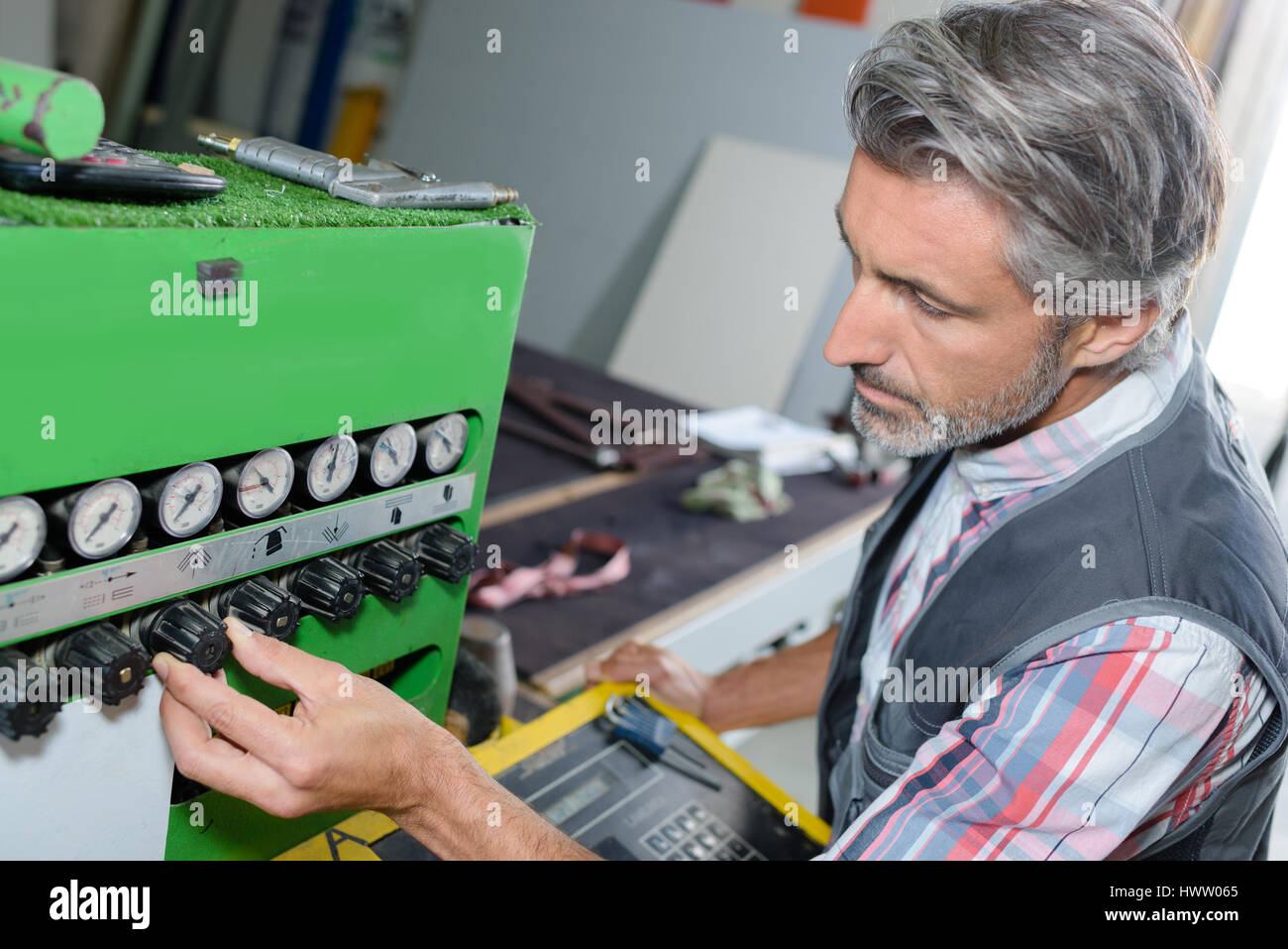 Man adjusting controls on industrial machine Stock Photo