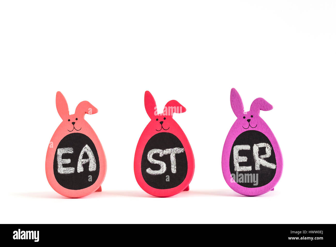 Written word Easter on three Bunny Eggs isolated on white. Greeting card concept, copy space