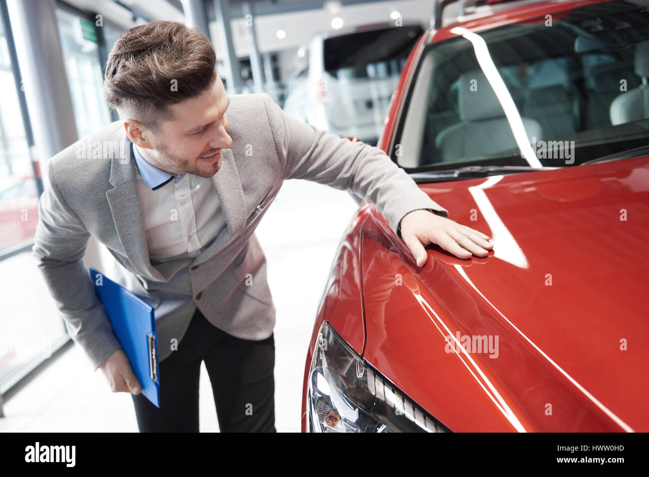 Car salesman examining vehicle before selling Stock Photo