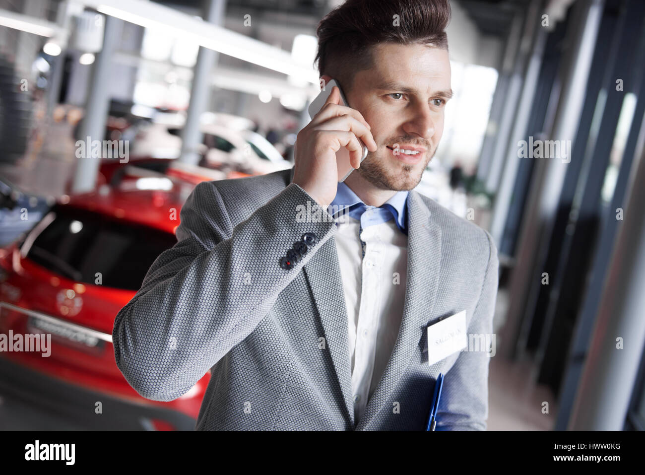 Car dealer having a call over work Stock Photo Alamy