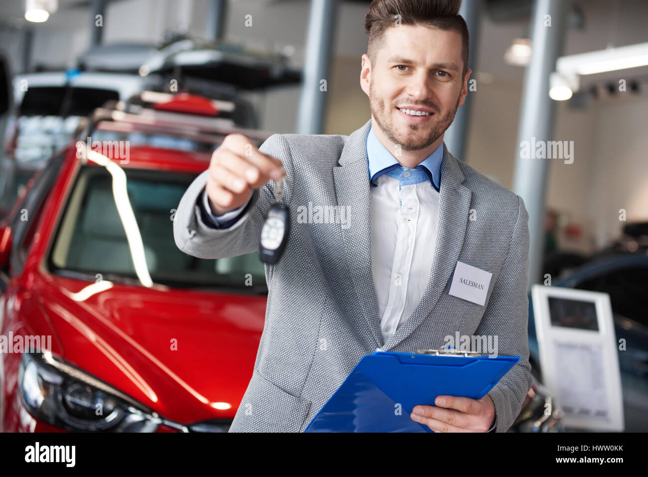 Smiling salesman handing car keys Stock Photo