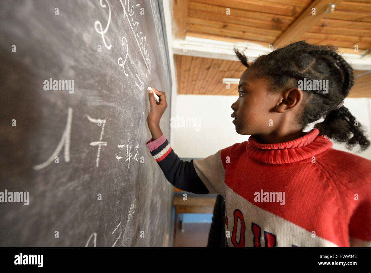 Madagaskar, Girl in Fianarantsoa elementary school calculatiing at blackboard Stock Photo