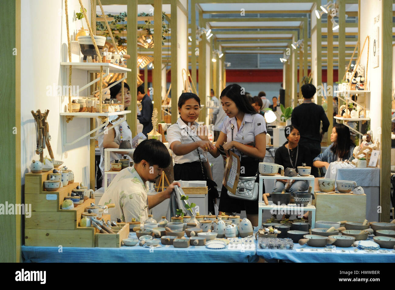 Bangkok, Thailand. 23rd Mar, 2017. Two students look at hand-made pottery during the International Innovative Craft Fair 2017 at the Bangkok International Trade & Exhibition Centre in Bangkok, Thailand, March 23, 2017. A total of 350 arts and crafts exhibitors worldwide presented their skills and products as the International Innovative Craft Fair (IICF) 2017 began on Thursday in Bangkok. The four-day event aims to facilitate experience sharing among international craftspeople and promote related tradings. Credit: Rachen Sageamsak/Xinhua/Alamy Live News Stock Photo