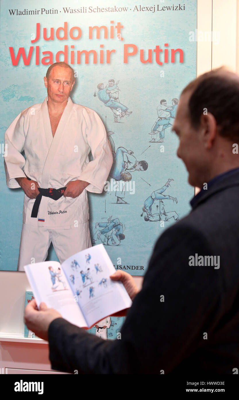 A man leafs through the book 'Judo with Vladimir Putin' at the Leipzig Book Fair in Leipzig, Germany, 23 March 2017. The book explains Judo techniques in 221 pages and 77 colour illustrations. The Russian President practices Judo and is a holder of the 9th Dan. Starting 23 March Leipzig becomes once more for four days the Mecca for authors, publishers and bibliophiles. Around 3400 presentations will take place in 570 stages until 26 March. Lithuania is under focus as a guest country. Last year the fair saw about 260 000 visitors. Photo: Jan Woitas/dpa-Zentralbild/dpa Stock Photo