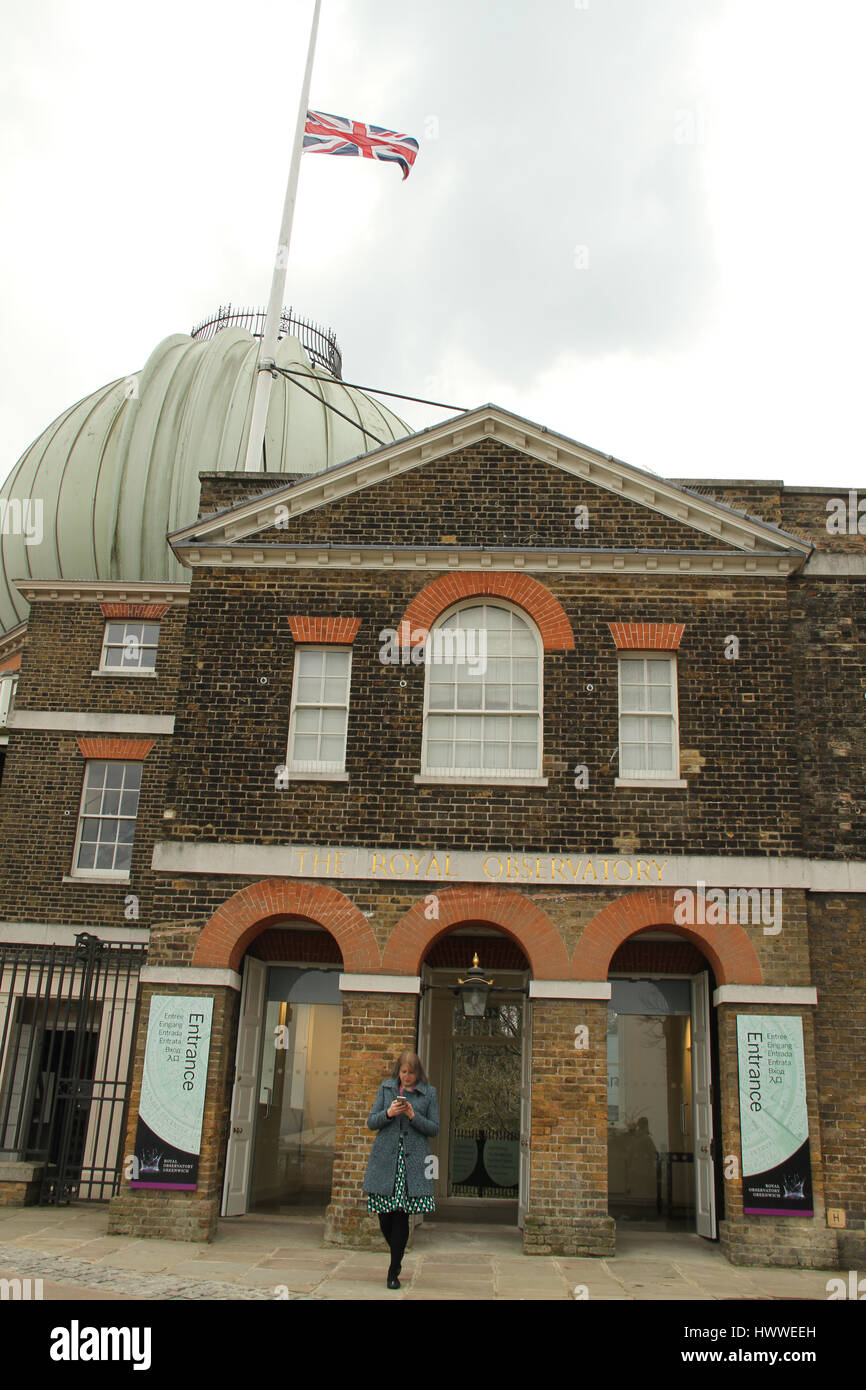 London, UK. 23rd Mar, 2017. A tourist walks out of the Royal Observatory as the Union Jack flag flies at half mast on March 23, 2017. Flags were hosted at half mast following the terror attack in Westminster on 22 March where four people lost their lives. Credit: David Mbiyu/Alamy Live News Stock Photo