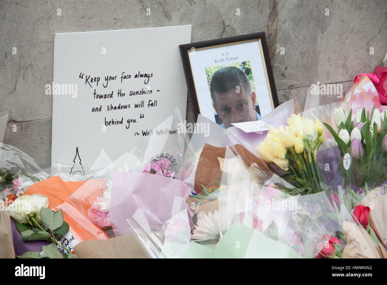 London UK.  24th March 2017. Floral tributes are placed around the picture of PC Keith Palmer by members of the public on Westminster Bridge after the terror attacks in Parliament Credit: amer ghazzal/Alamy Live News Stock Photo