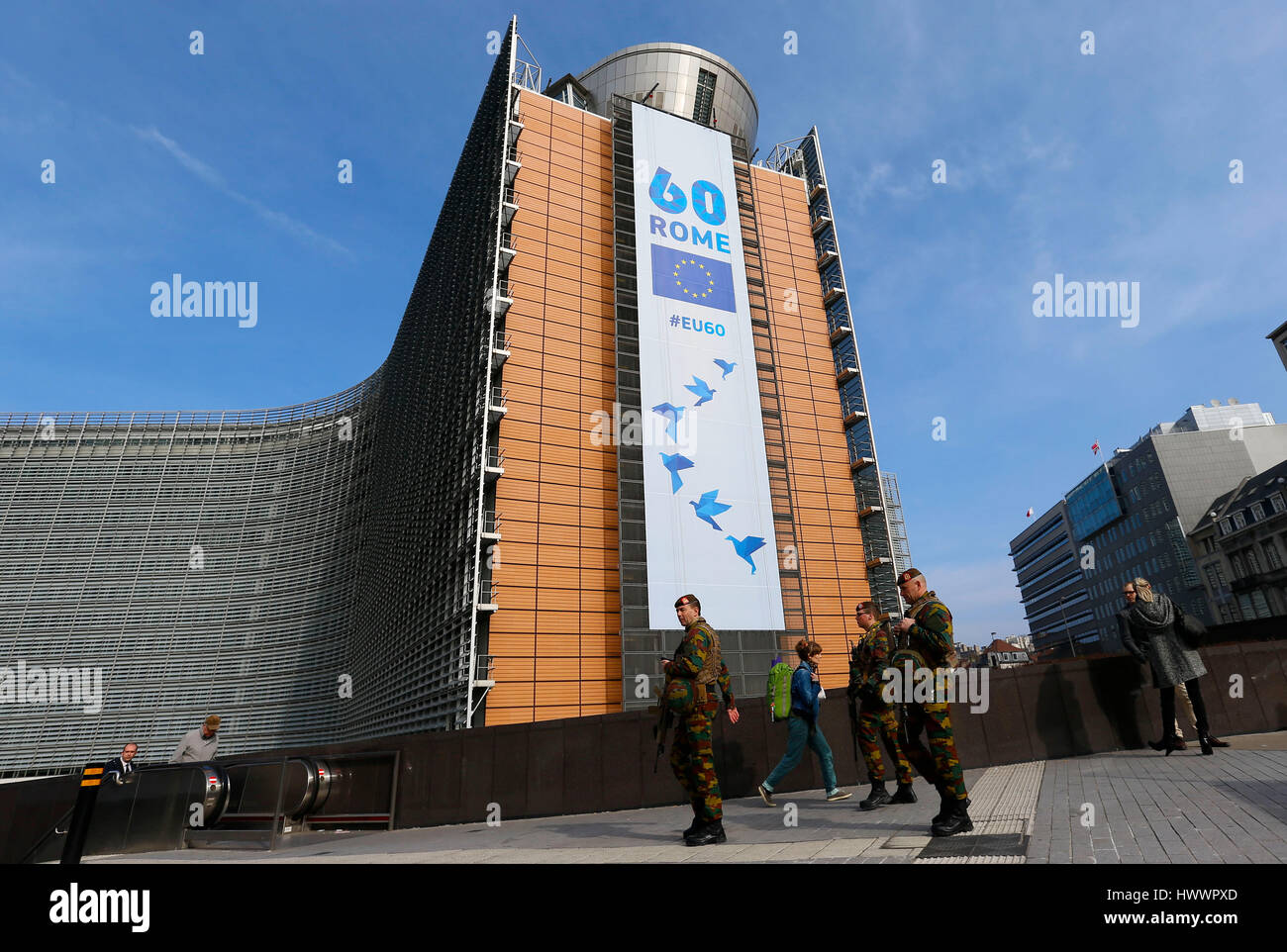 Brussels, Belgium. 24th Mar, 2017. Belgian soldiers patrol in front of European Commission building on which a banner is displayed celebrating the 60th anniversary of Treaty of Rome, in Brussels, Belgium, March 24, 2017. The EU-27 leaders will meet in Rome on Saturday to celebrate the 60th anniversary of signing of the treaty and discuss about the future of the bloc without Britain. Credit: Ye Pingfan/Xinhua/Alamy Live News Stock Photo