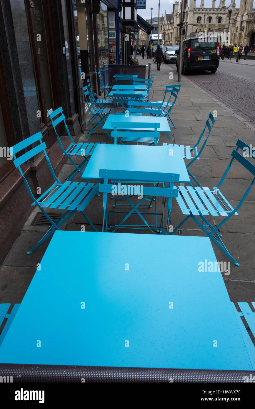 Blue tables and chairs on pavement outside eatery Kings Parade Cambridge City Cambridgeshire England Stock Photo