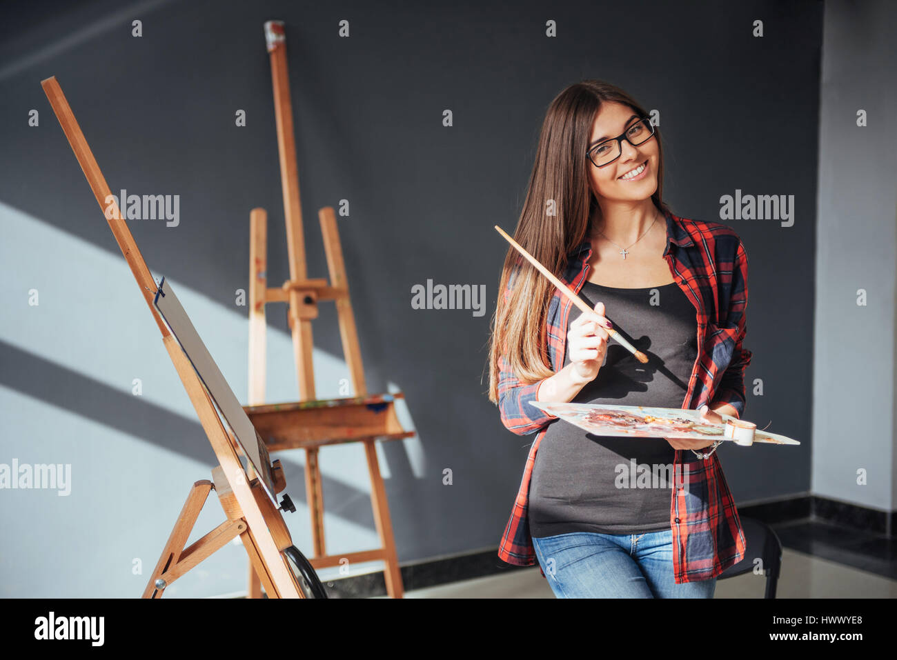 Young woman artist painting a picture in studio Stock Photo - Alamy