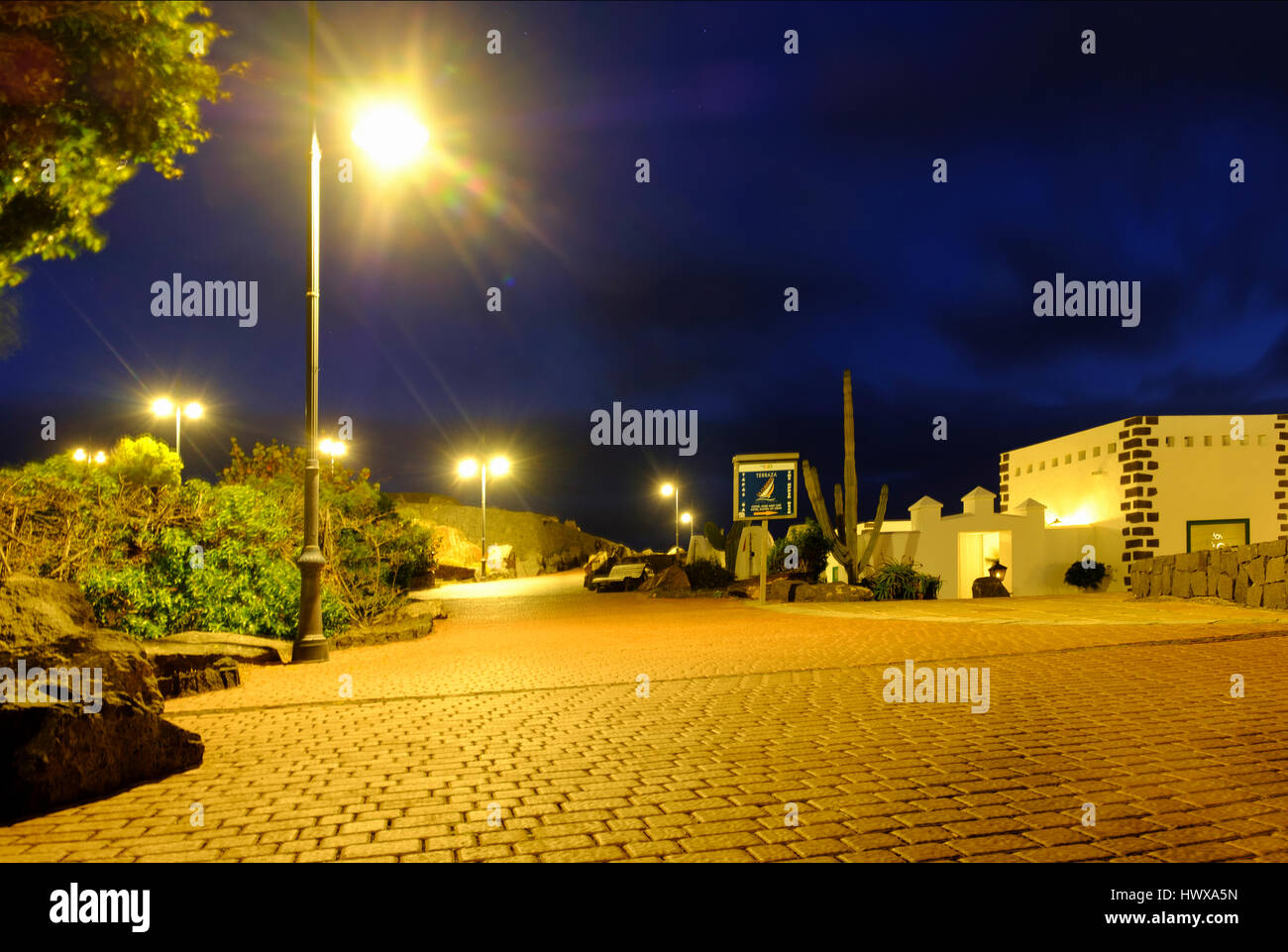 A night shot of he paved walkway at port rubicon, playa Blanca, lanzarote its illuminated by street lights Stock Photo
