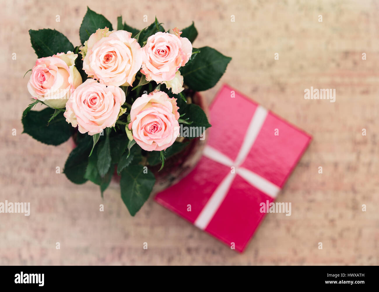Vase with roses and gift with ribbon Stock Photo Alamy