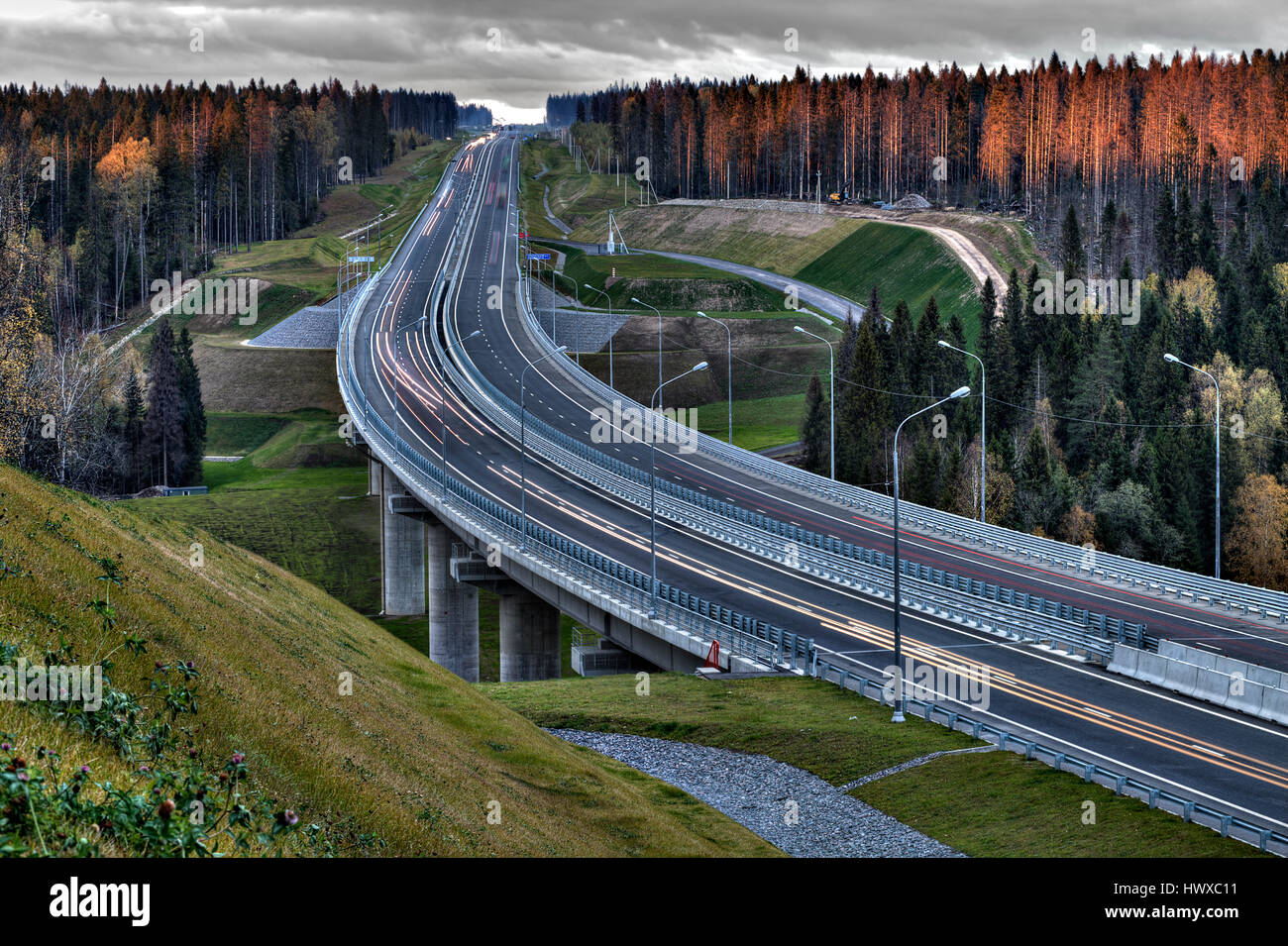 Llight trails Speedway in Russian forest at sunset. Stock Photo