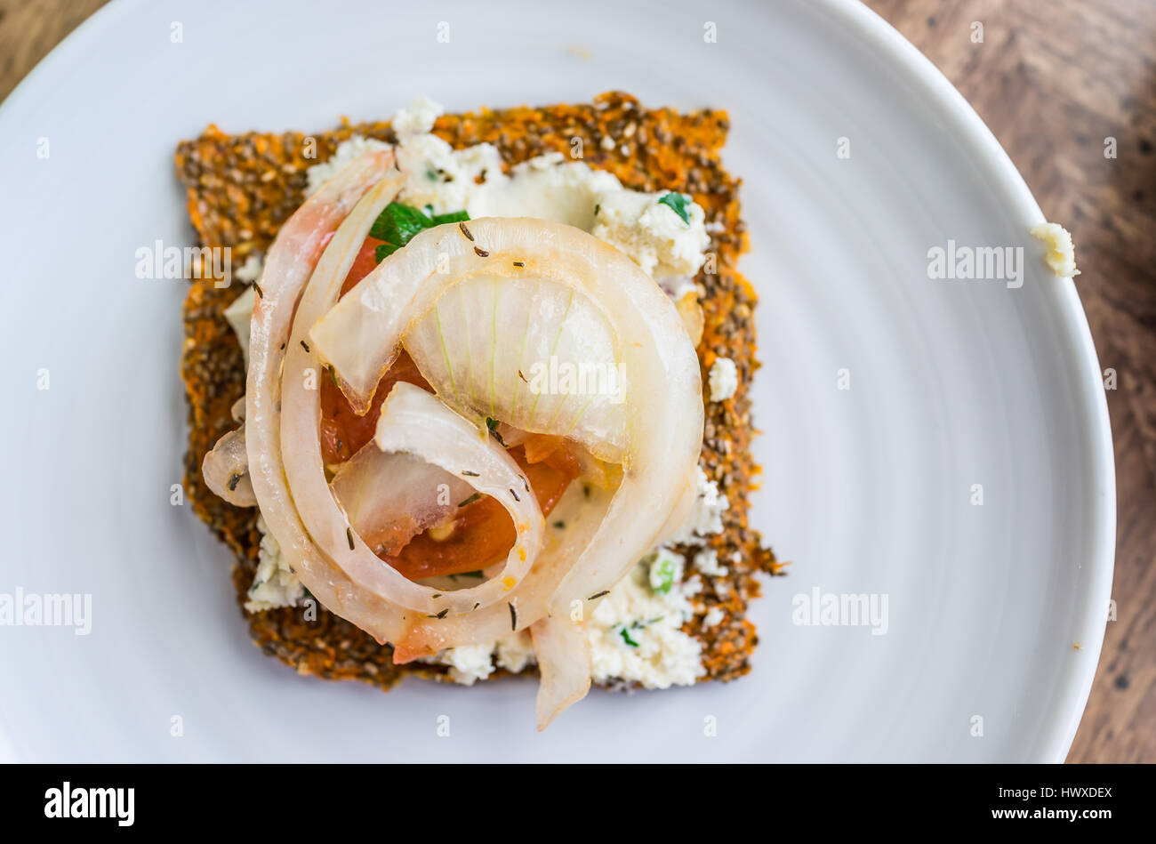 Macro closeup of healthy onion appetizer on chia flatbread toast and cheese Stock Photo