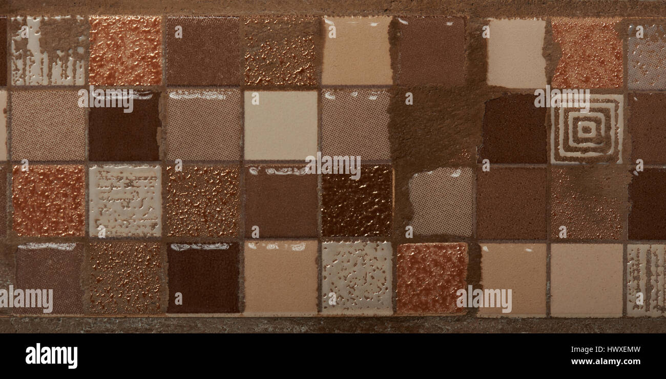 Small ceramic brown square tiles surface closeup. Wall decoration for bathroom Stock Photo