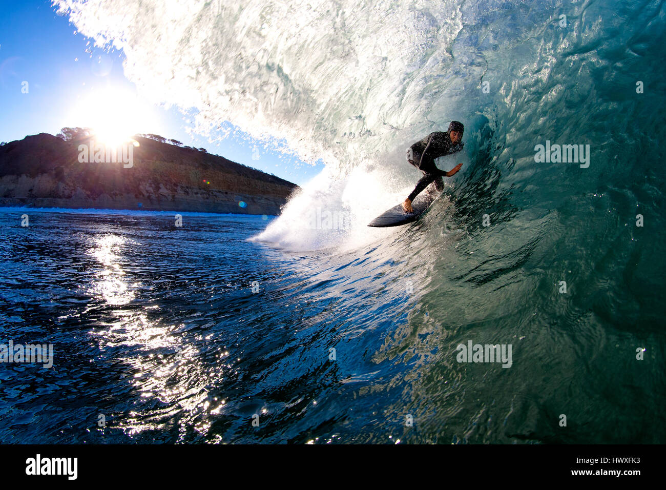 David Suhadolnik surfing in the tube at sunrise at Torrey Pines State Beach, San Diego, California. Stock Photo