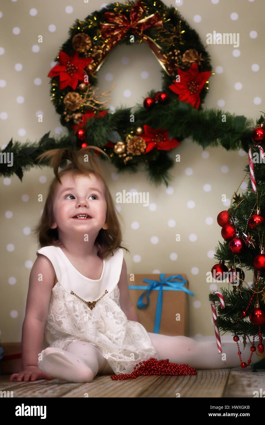 cute little girl dresses up Christmas tree Stock Photo - Alamy