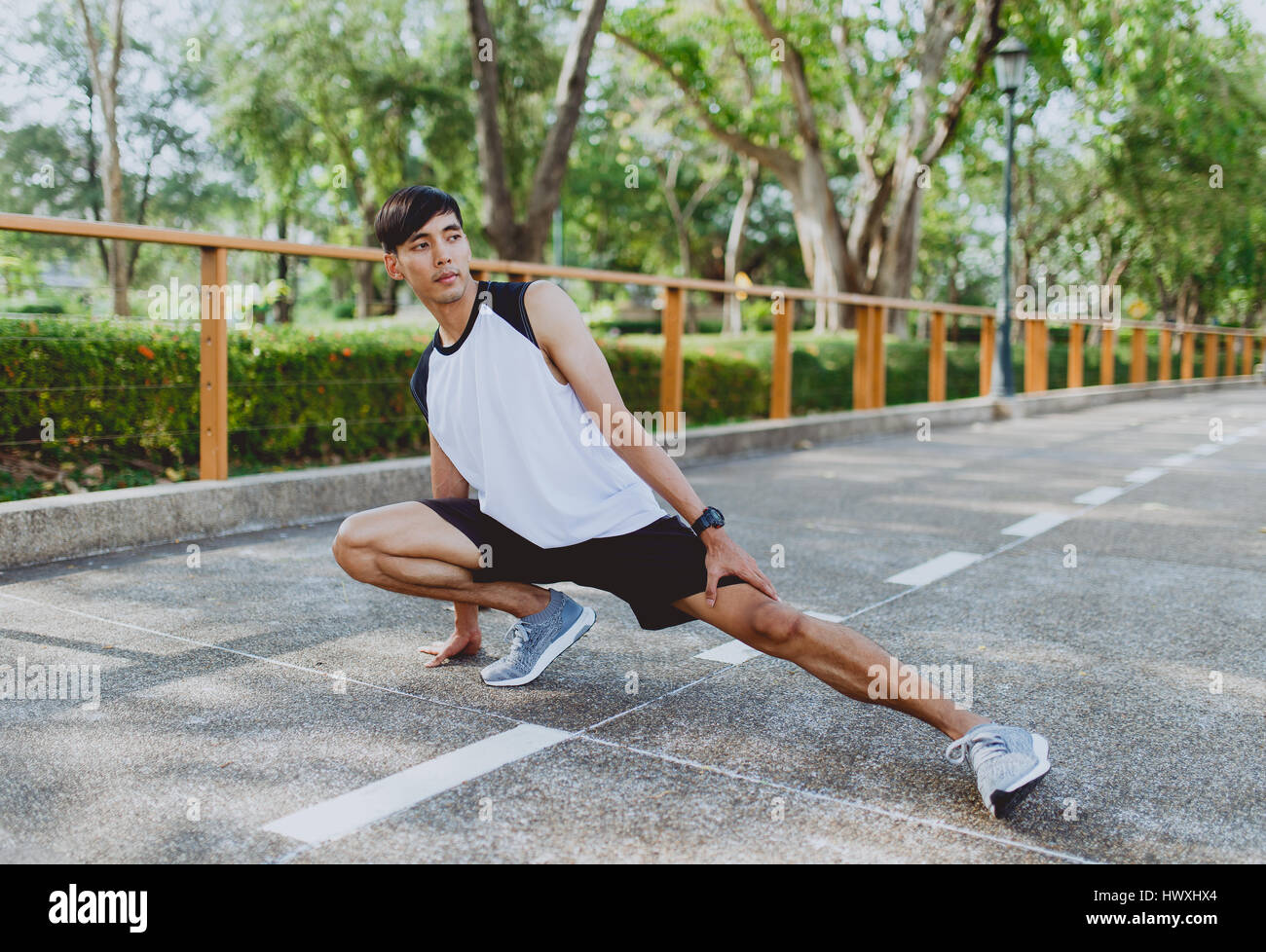 Young man stretching legs in park hi-res stock photography and images ...