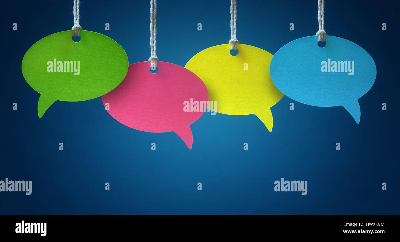 Blank colorful speech bubbles hanging from a cord over blue background Stock Photo