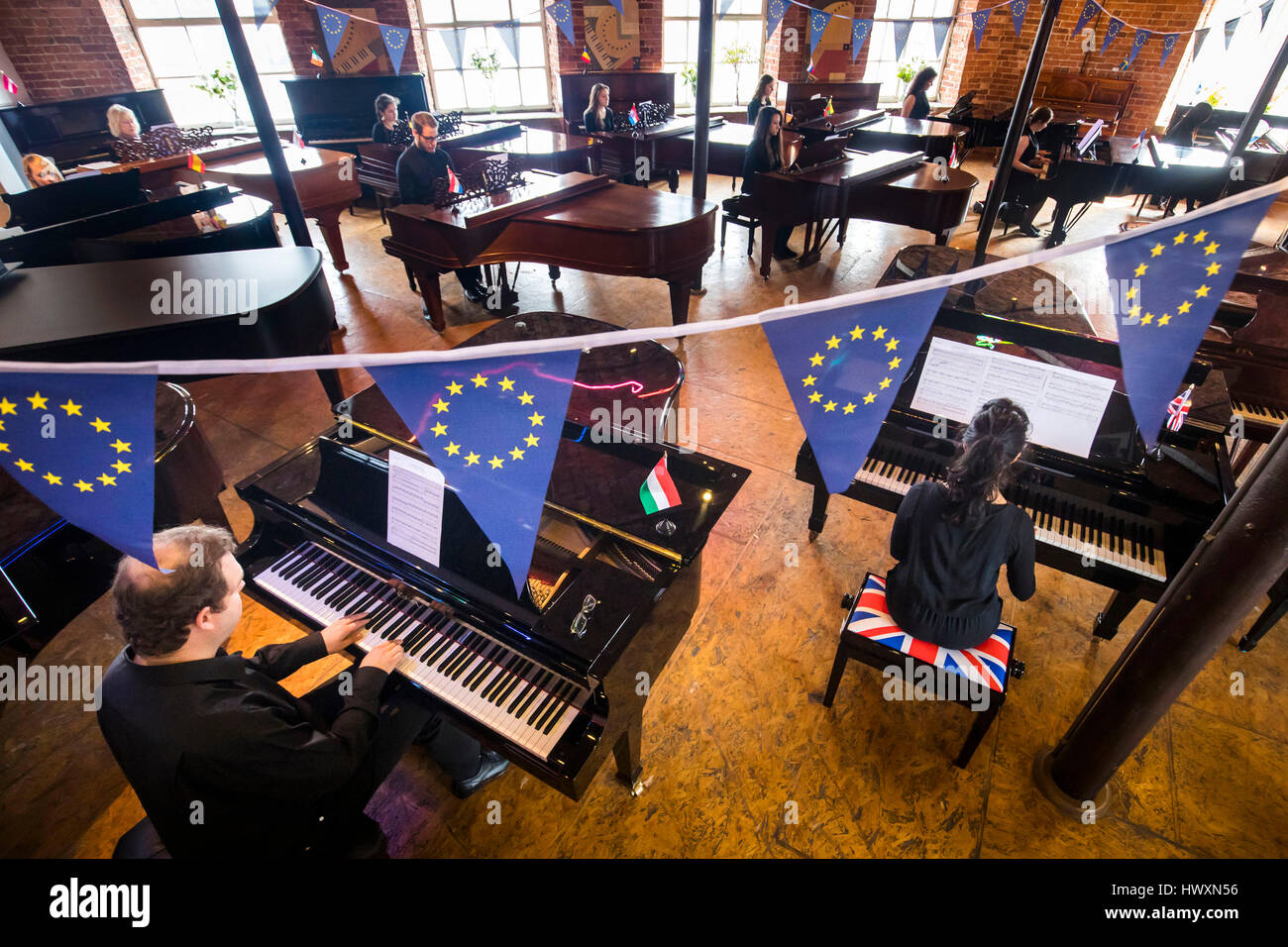28 pianists, representing the members of the European Union, play 28 Steinways pianos symbolising Brexit at Besbrode Pianos in Leeds, during a preview of artwork 'European Unison' by artist Ruth Spencer Jolly. Stock Photo